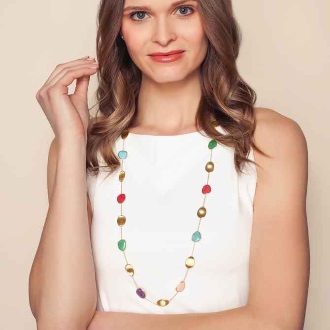 Woman wearing colored gemstone station necklace