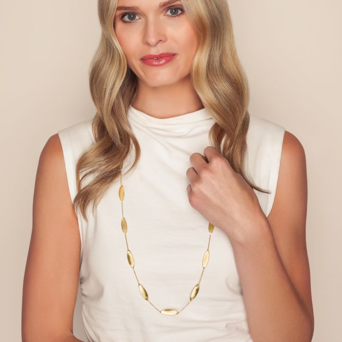 Woman wearing gold station necklace