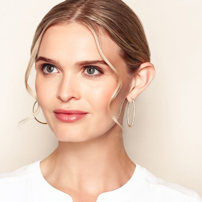 Woman wearing 1.5 cttw yellow gold inside out diamond hoops