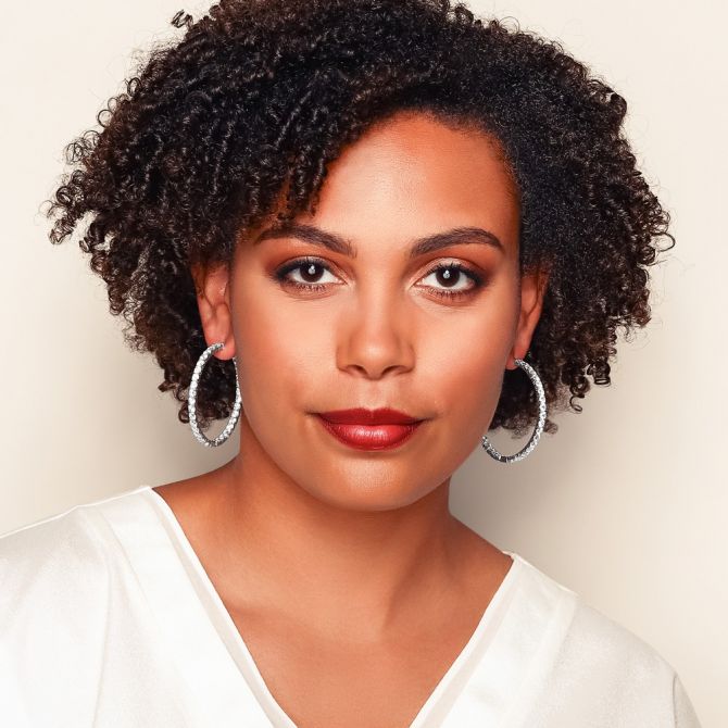 Woman wearing 14 cttw white gold inside out diamond hoops