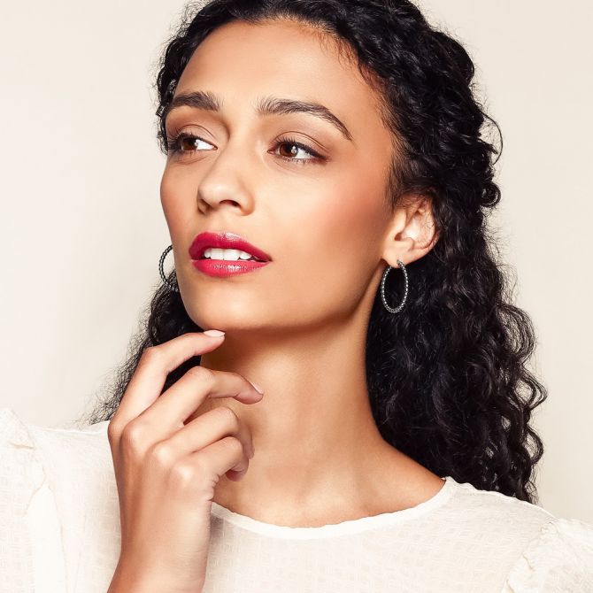 Woman wearing sterling silver hoop earrings under $100
