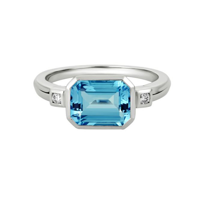 Emerald Cut Blue Topaz & Diamond Side Stone Bezel Set 3 Stone Ring in White Gold